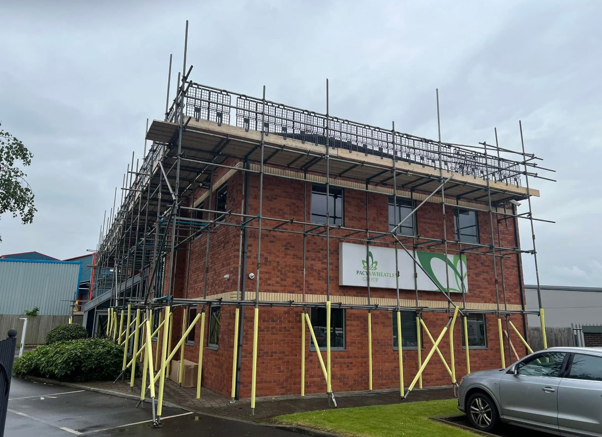Pacy & Wheatley building exterior wrapped in full-height scaffolding for exterior repair project